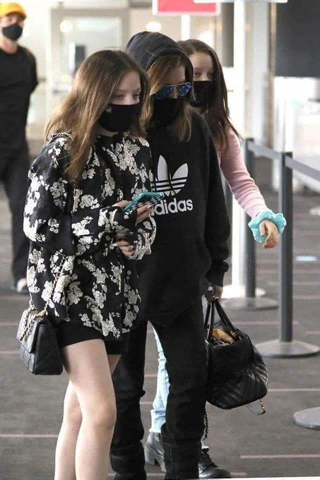 Two Girls Wearing Face Masks Are Walking Through An Airport