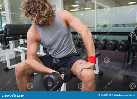 Hombre Joven Que Ejercita Con Pesa De Gimnasia En Gimnasio Imagen De