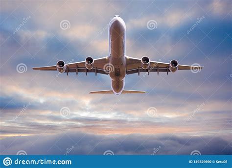 Commercial Airplane Jetliner Flying Above Dramatic Clouds Stock Photo