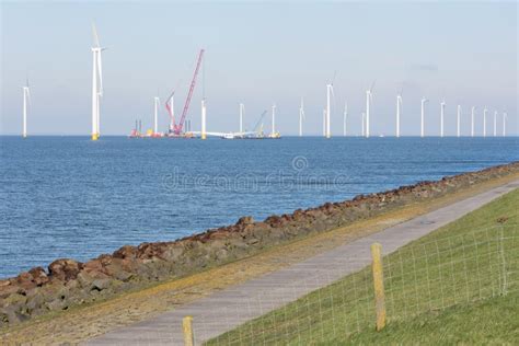 Costa Holandesa Con Aerogeneradores Y Hermoso Cielo Nublado Imagen De