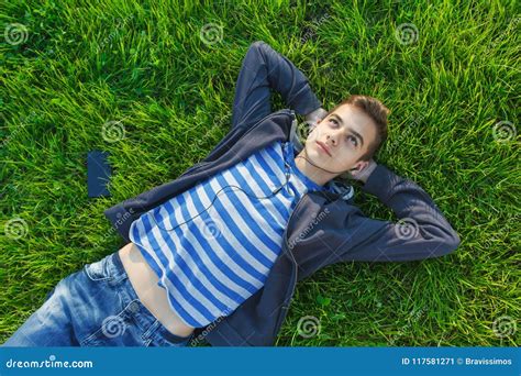 Portrait Cute Teen Boy Listening Music Lying Down On Fresh Green