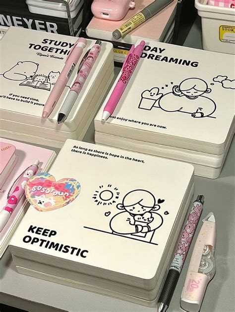 Three Notebooks With Cartoon Drawings On Them And Pens Next To Each