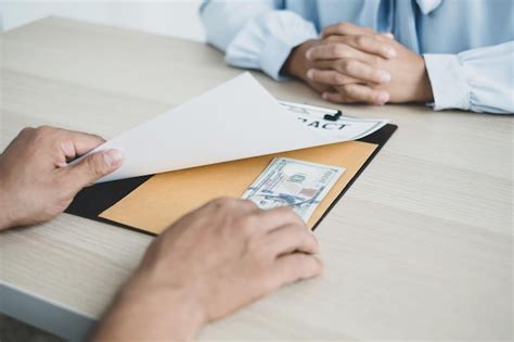 Premium Photo Midsection Of Man Holding Paper While Sitting On Table