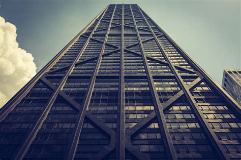 Looking Up At A Tall Dark Skyscraper With Windows And Diagonal And