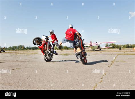 Two stunt riders making wheelie Stock Photo - Alamy