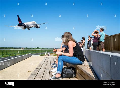 Plane spotters on aircraft spotting platform watching airplane from Brussels Airlines taking off ...