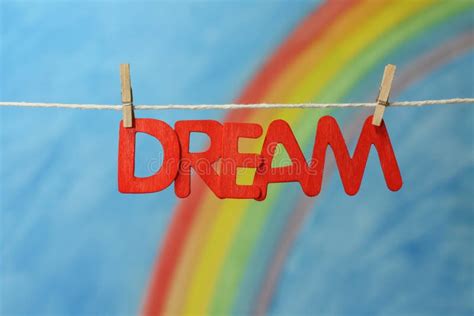 The Word Dream With A Colorful Rainbow And Blue Sky Background Stock