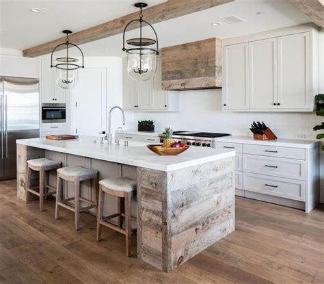 a large kitchen with white cabinets and wooden beams on the ceiling, along with two stools