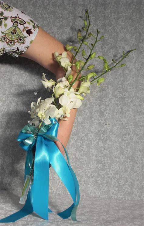 A Woman S Hand Holding A Bouquet Of White Flowers And Blue Ribbon On A