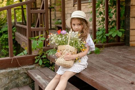 Jolie Petite Fille En Robe Légère Et Chapeau De Paille Tenant Un Panier