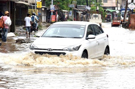 A Vehicle Move Through A Waterlogged Road After Heavy Rainfall