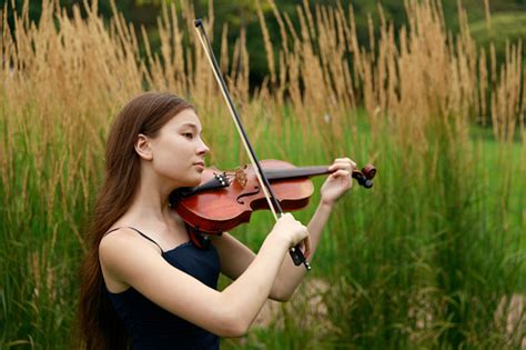 Beautiful Brownhaired Girl Of Asian Appearance With A Violin In Nature Musician In Nature