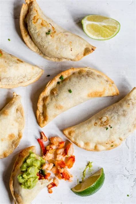 Some Food Is Laying Out On A White Surface With Limes And A Slice Of Lime