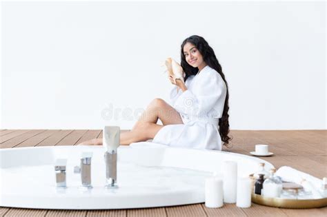 Beautiful Brunette Woman With Long Hair Relaxing Near Round Bath Holding Seashell Enjoying
