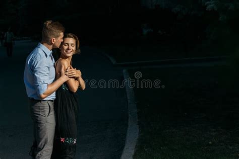 Happy Loving Couple Hugging Guy Kisses A Girl And Hugs From Behind