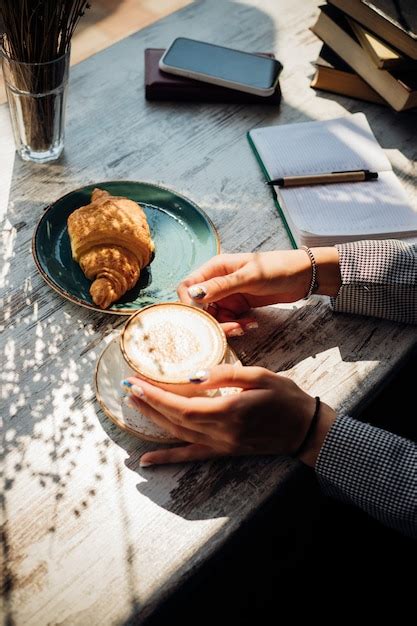 Premium Photo Cappuccino And Croissant On The Table In The Cafe The