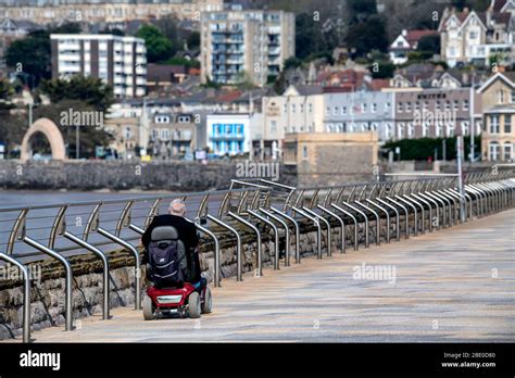 A man on a mobility scooter rides along Royal Parade past the Grand ...