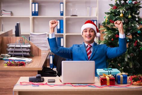 Young Male Employee Celebrating Christmas At Workplace Stock Image