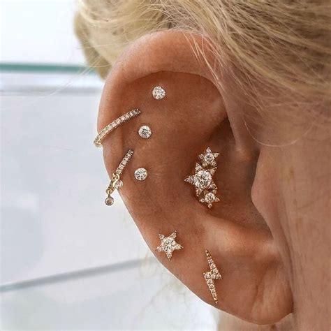 A Close Up Of A Person Wearing Ear Piercings With Diamond Stars On The