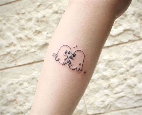 A Small Tattoo On The Arm Of A Woman With Two Elephants Hugging Each