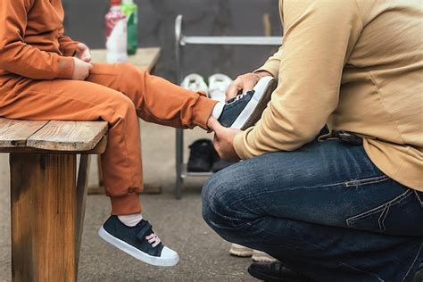 Un hombre cuida y cuida a su pequeña hija y la ayuda a ponerse las