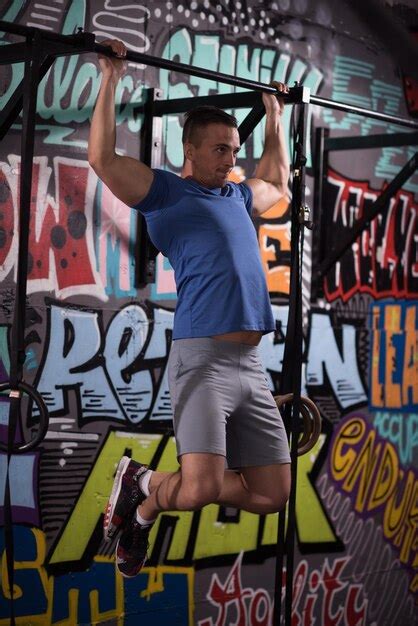 Premium Photo Strong Young Man Doing Pull Ups On A Bar In A Gym