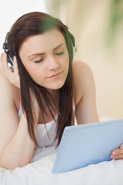 Premium Photo Relaxed Girl Listening To Music And Using A Tablet Pc