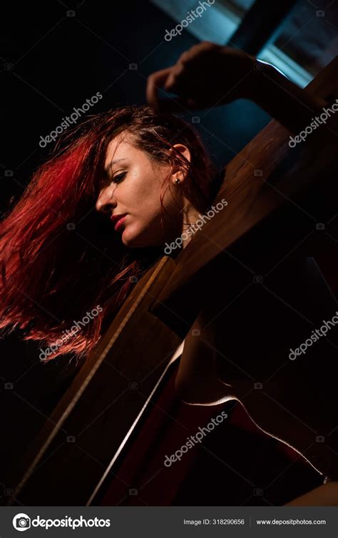 A Redhead Woman With A Naked Group Is Enclosed In A Wooden Pillory