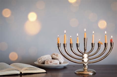 Chanukah Menorah With Jelly Doughnuts And Torah Book Stock Photo