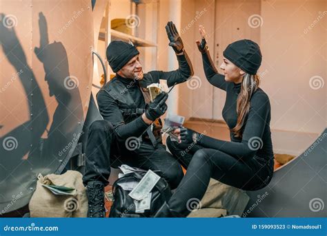 Two Robbers In Black Uniform Stuff Bags With Money Stock Image Image