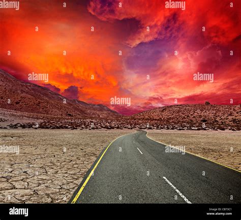 Road in desert on sunset Stock Photo - Alamy