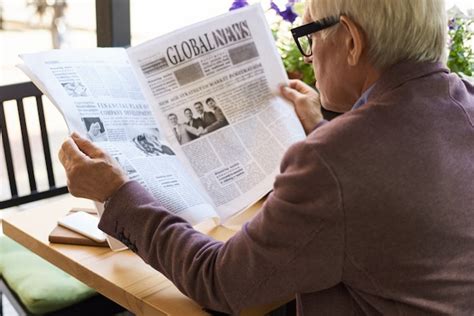 Senior Hombre Está Leyendo El Periódico En Casa Foto Premium