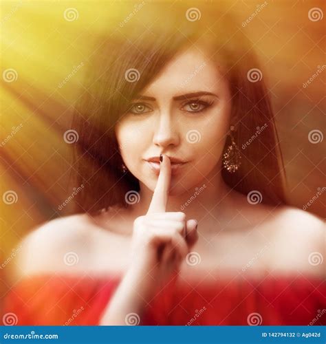 Young Woman With Dark Long Hair Saying Shh With Forefinger On Lips