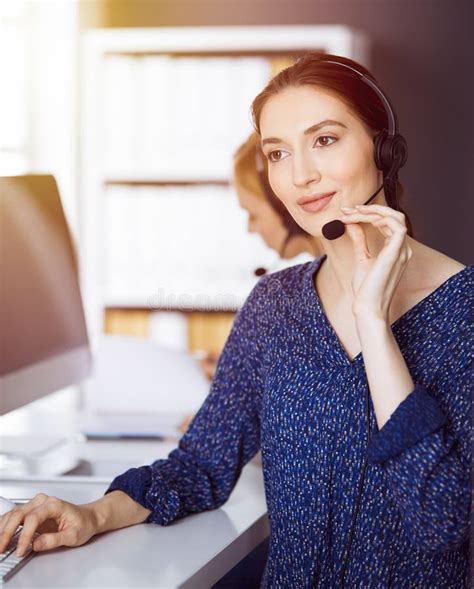 Latin American Businesswoman Talking By Headset In Sunny Office Call