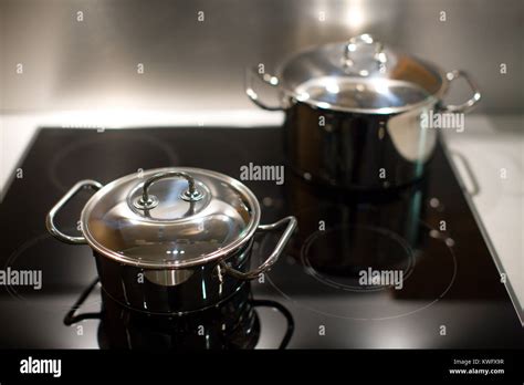 Two New Stainless Steel Saucepans On Modern Kitchen Range Stock Photo