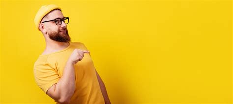 Premium Photo Smiling Bearded Man In Glasses Pointing Over Empty