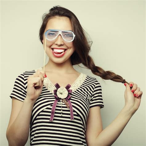 Imagen de fiesta mujeres jóvenes juguetonas sosteniendo unas gafas de