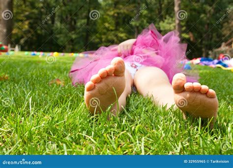 Happy Little Girl Lying On Grass