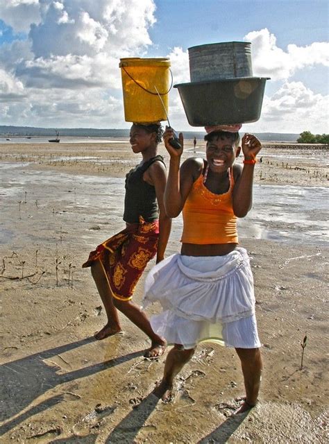 Two Women Carrying Buckets On Their Heads