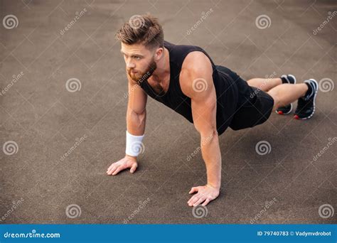 Handsome Young Man Athlete Training And Doing Plank Exercise Outdoors