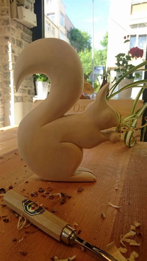 A White Swan Sculpture Sitting On Top Of A Wooden Table Next To A Pen