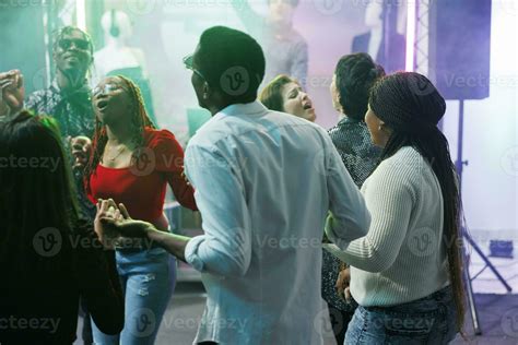 Diverse People Clubbing And Dancing Together At Discotheque Party Event