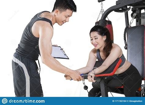 Mujer Haciendo Ejercicio En El Equipo De Gimnasia Con Entrenador Foto