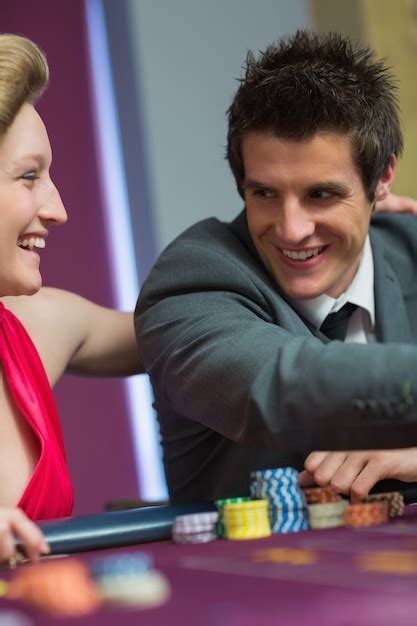 Pareja Sonriendo El Uno Al Otro En La Mesa De Ruleta Foto Premium