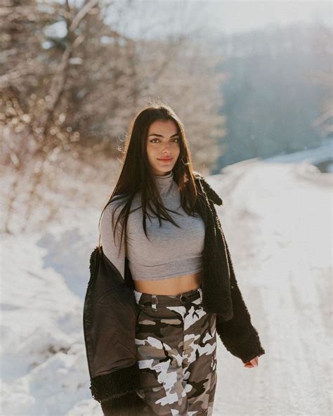 a woman walking down a snow covered road