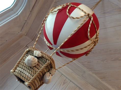 A Red And White Striped Hot Air Balloon Hanging From A Ceiling With