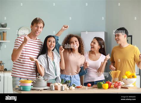 Happy Friends Cooking Together In Kitchen Stock Photo Alamy