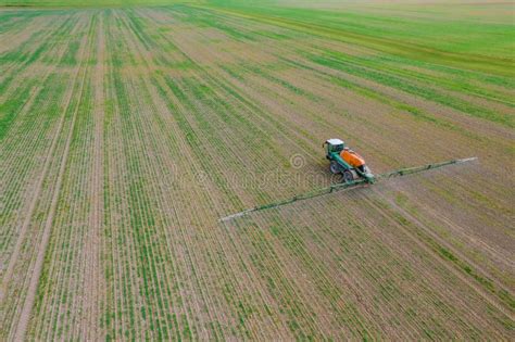 Trator Pulveriza O Campo Fertilizante Ou Herbicida Imagem De Stock