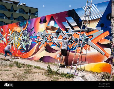 Graffiti Artists Hard At Work Painting An Old Wall Friedrichshain