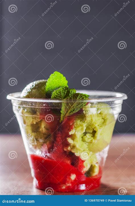 Green Organic Avocado Ice Cream And Strawberry Sorbet With Red Wine In A Plastic Cup With Mint